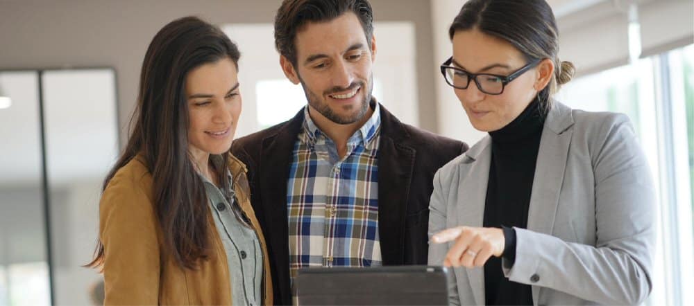 three people looking at a laptop